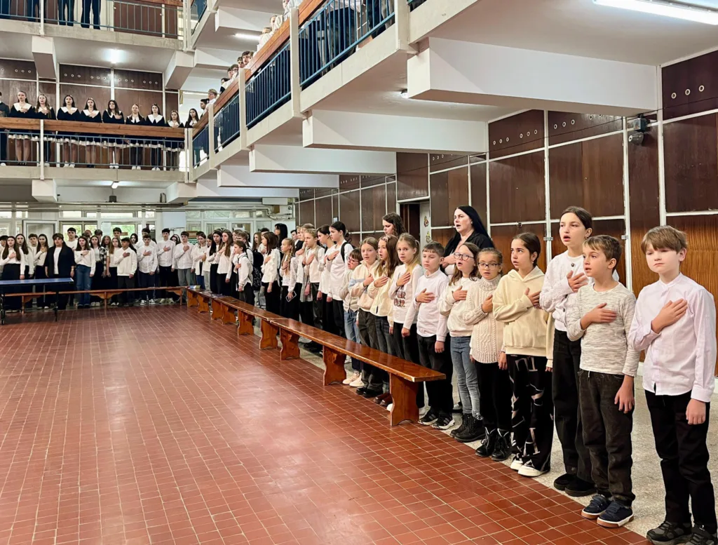 Учні співають гімн у шкільному холі