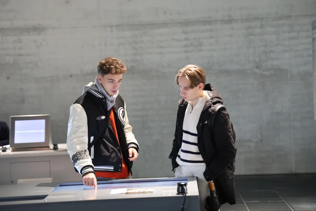 Двоє хлопців переглядають інтерактивний екран у музеї