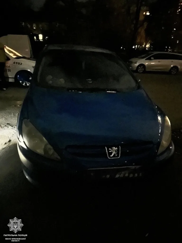 Синій автомобіль Peugeot на нічній парковці