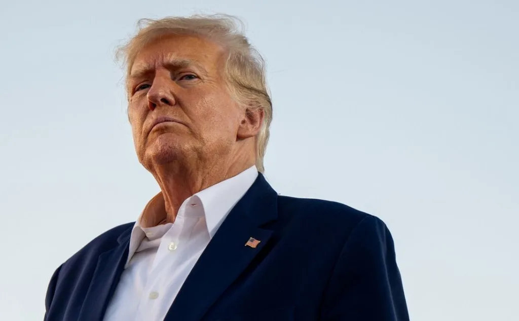 Чоловік у костюмі дивиться вгору на небі