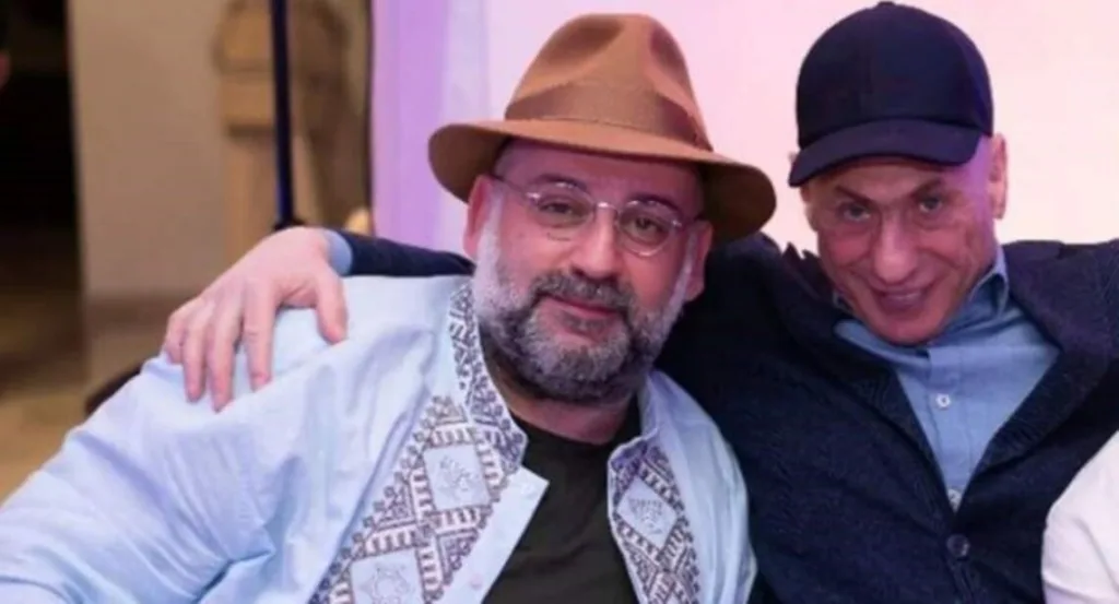 Двоє чоловіків посміхаються, обіймаючись на фото