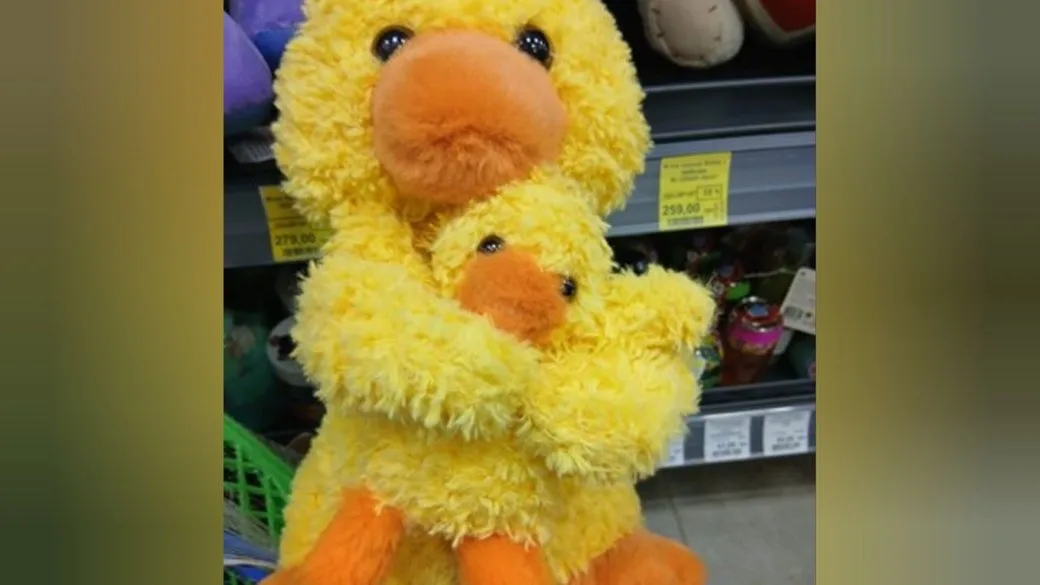 Дві жовті плюшеві качки в обіймах у магазині