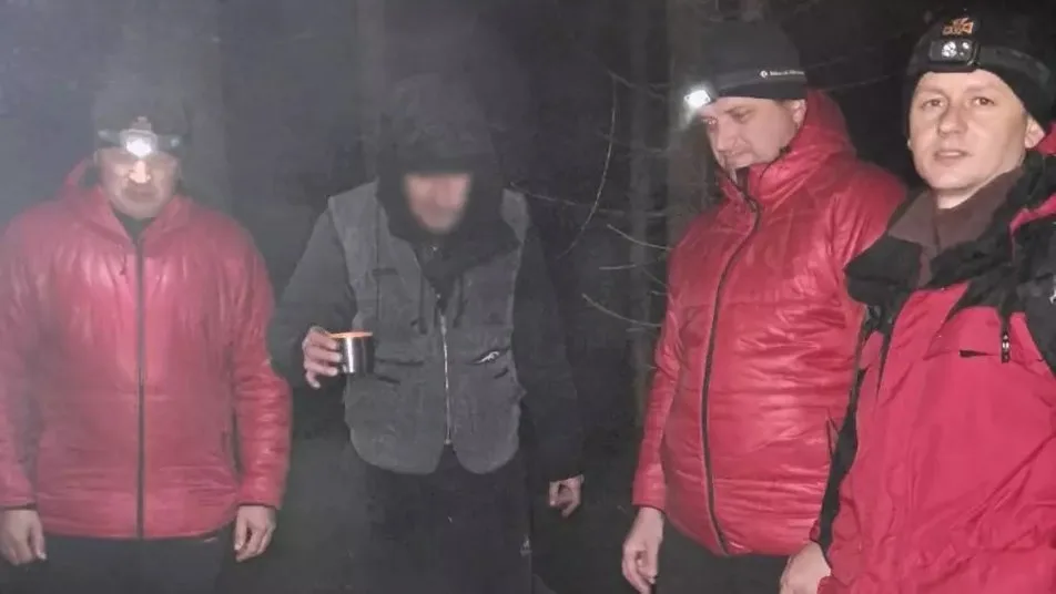 Туристи з ліхтариками у нічному лісі