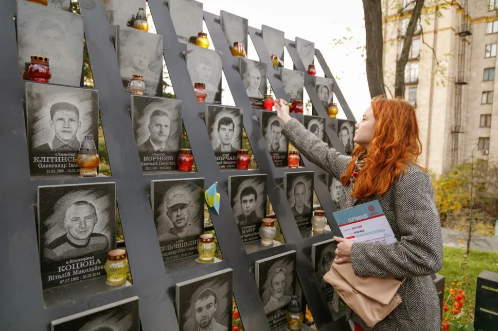 Жінка вшановує героїв на меморіалі Небесної Сотні