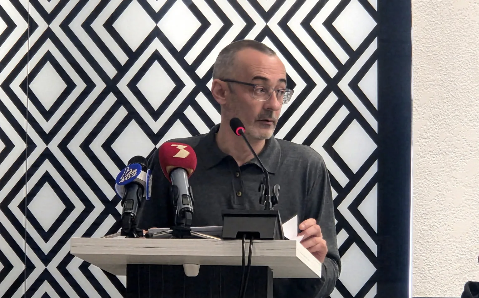 Чоловік говорить на пресконференції біля мікрофонів