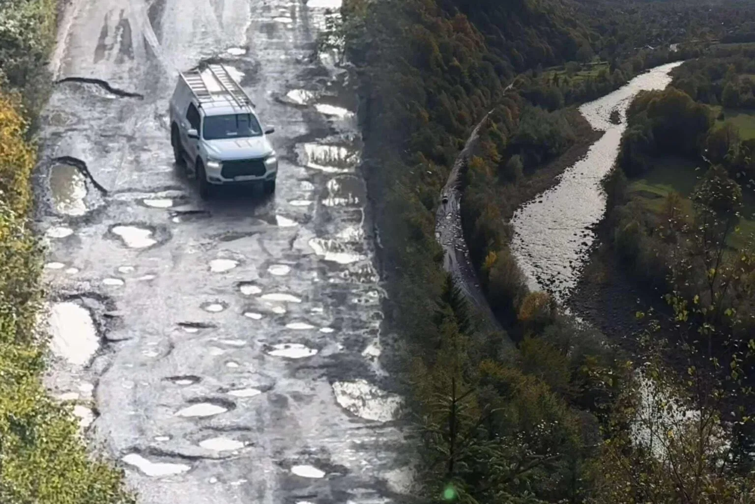 Автомобіль їде розбитою дорогою біля річки