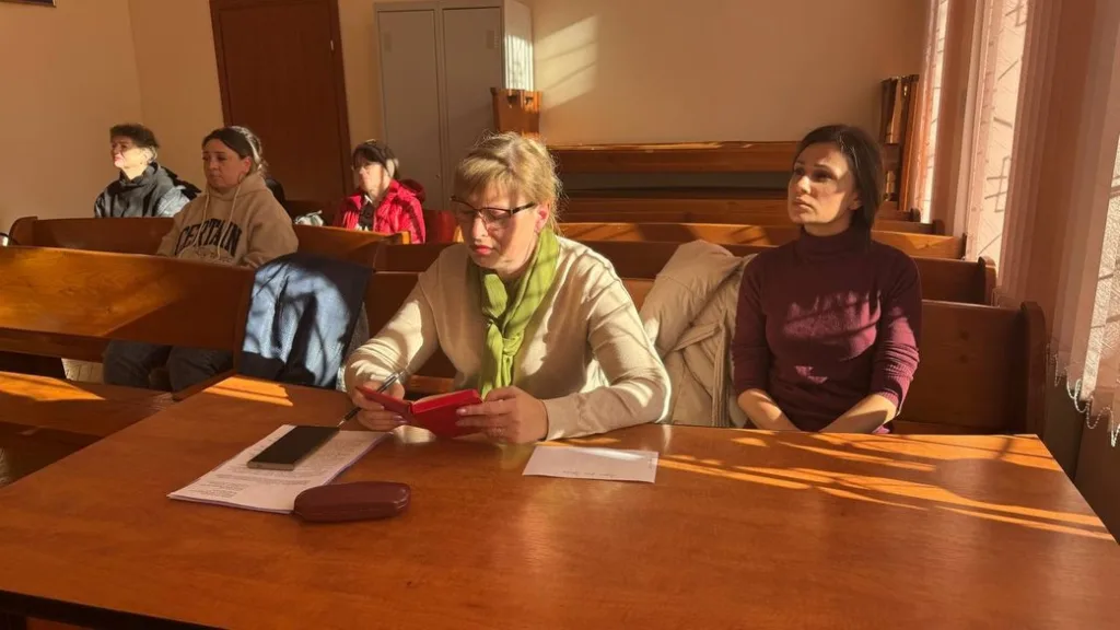 Люди сидять у залі під час зустрічі