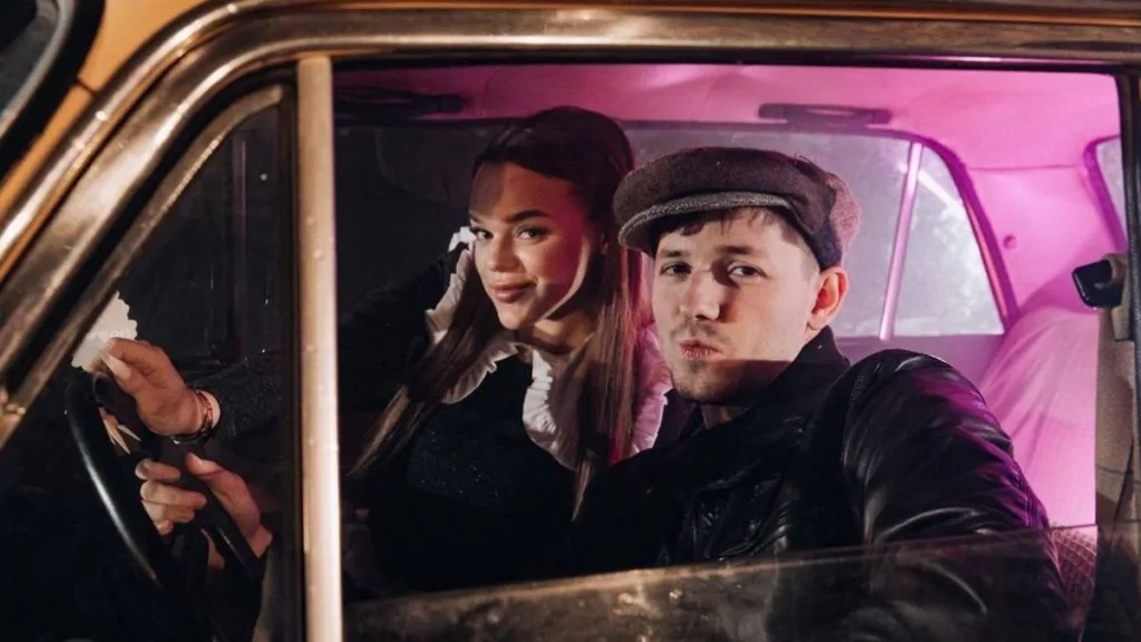 Молода пара сидить у старому автомобілі