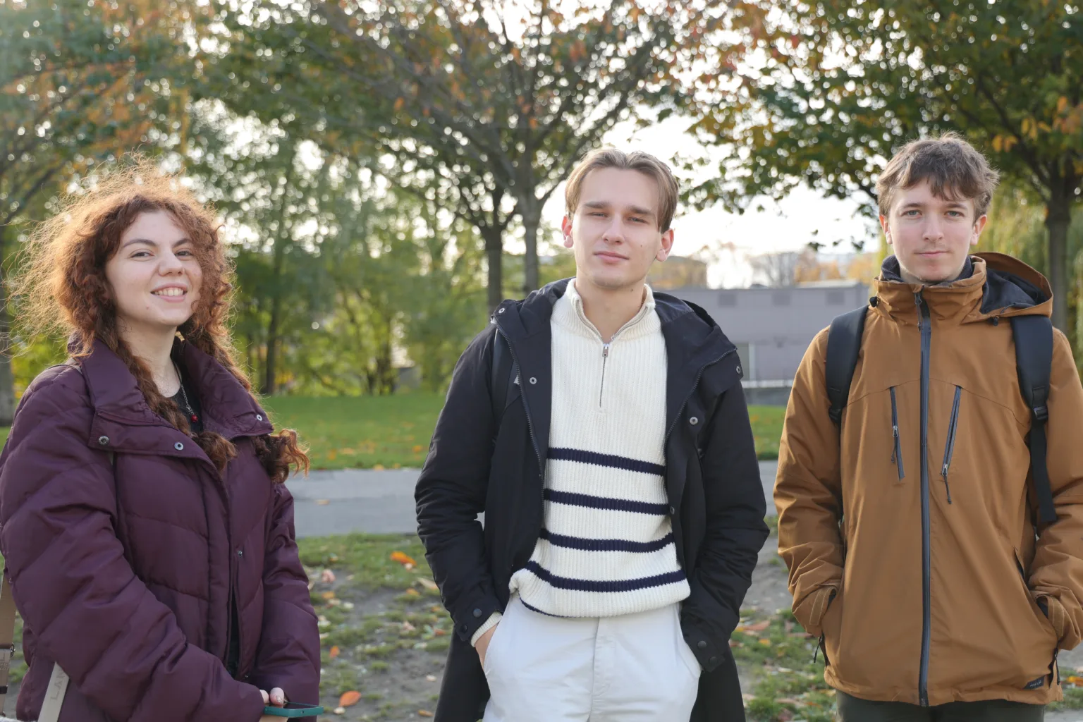Троє друзів стоять у парку восени