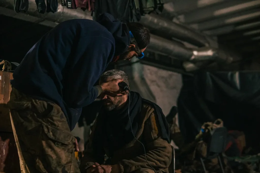 Військовий підстригає товариша у темному приміщенні