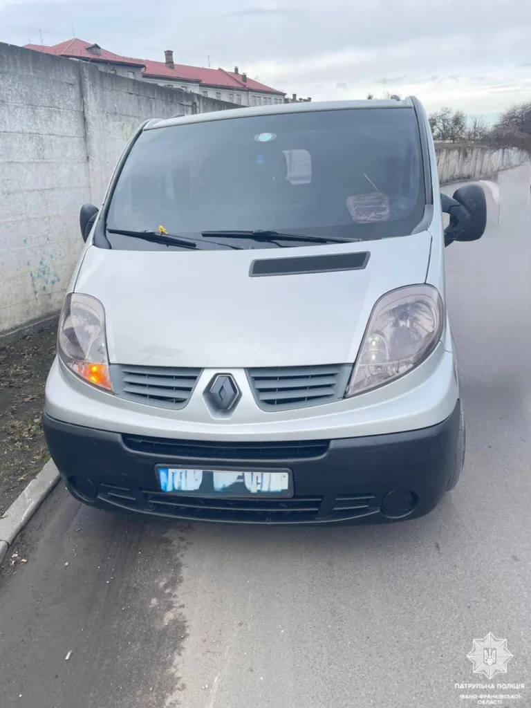Білий мікроавтобус Renault припаркований біля стіни