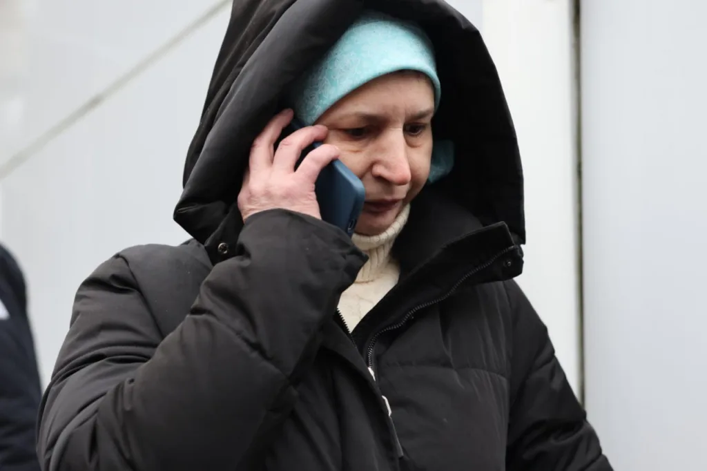 Жінка в зимовому одязі говорить по телефону