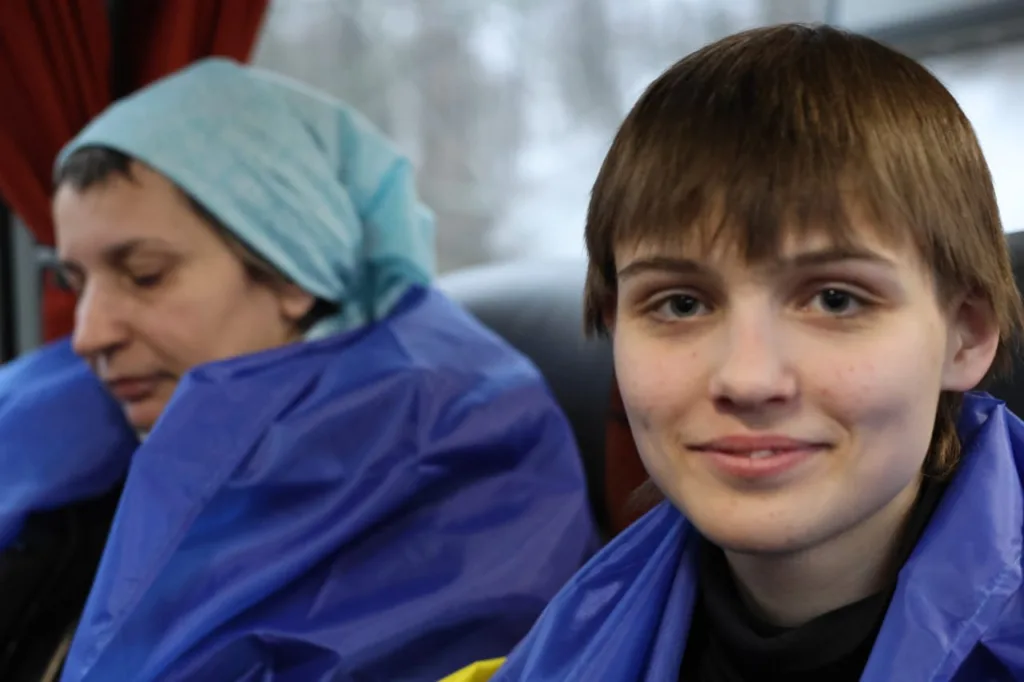 Дві людини у синіх плащах у транспорті