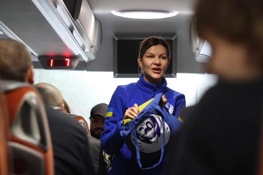 Жінка у спортивному костюмі говорить у автобусі