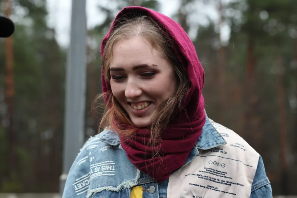 Усміхнена дівчина в бордовій хустці на вулиці