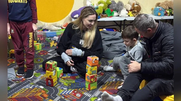 Дорослі та діти грають кубиками у дитячій кімнаті