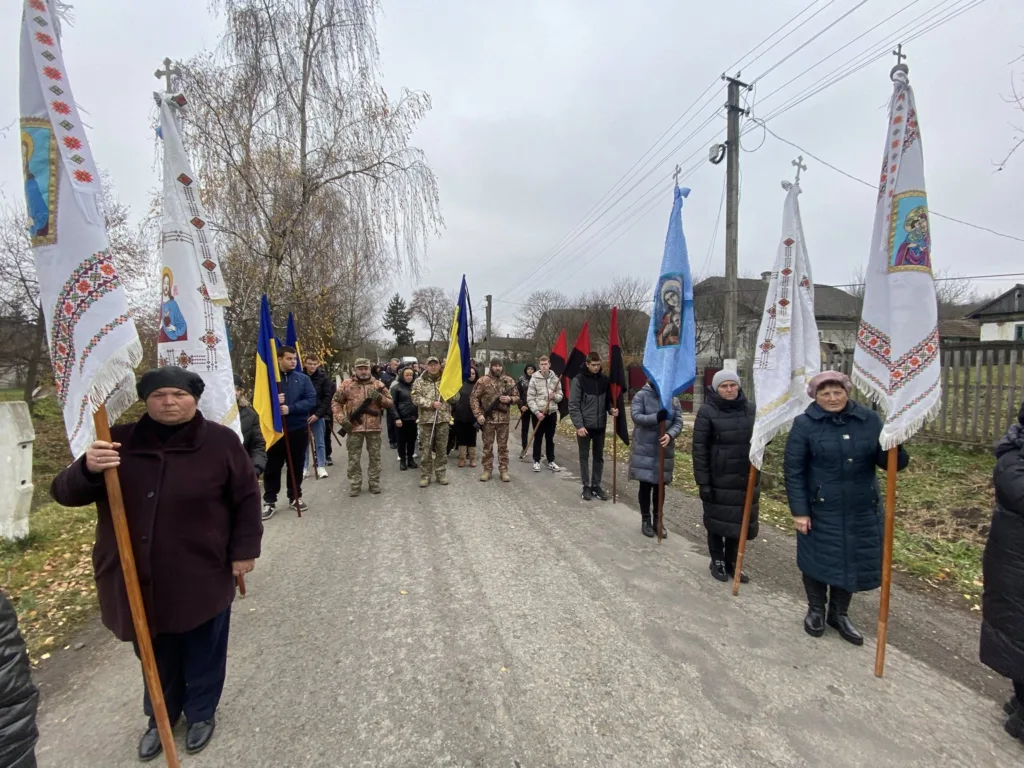 Люди з прапорами на вулиці українського села
