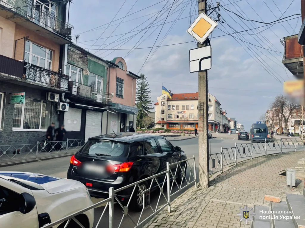 Вулиця українського міста з будинками та автомобілями