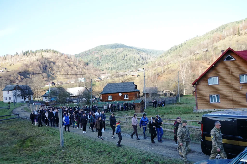 Люди йдуть селом у гірській місцевості України