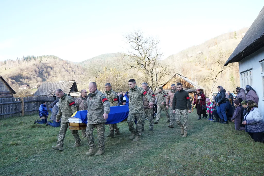 Військові несуть труну з українським прапором