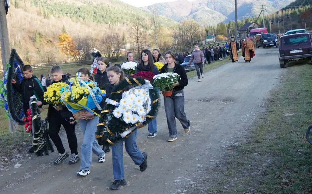 Люди несуть квіти та вінки на похорон