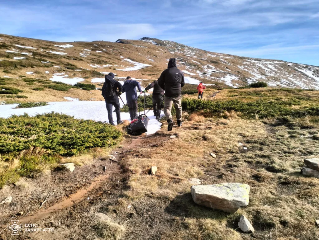 Рятувальники піднімаються гірською стежкою з носилками