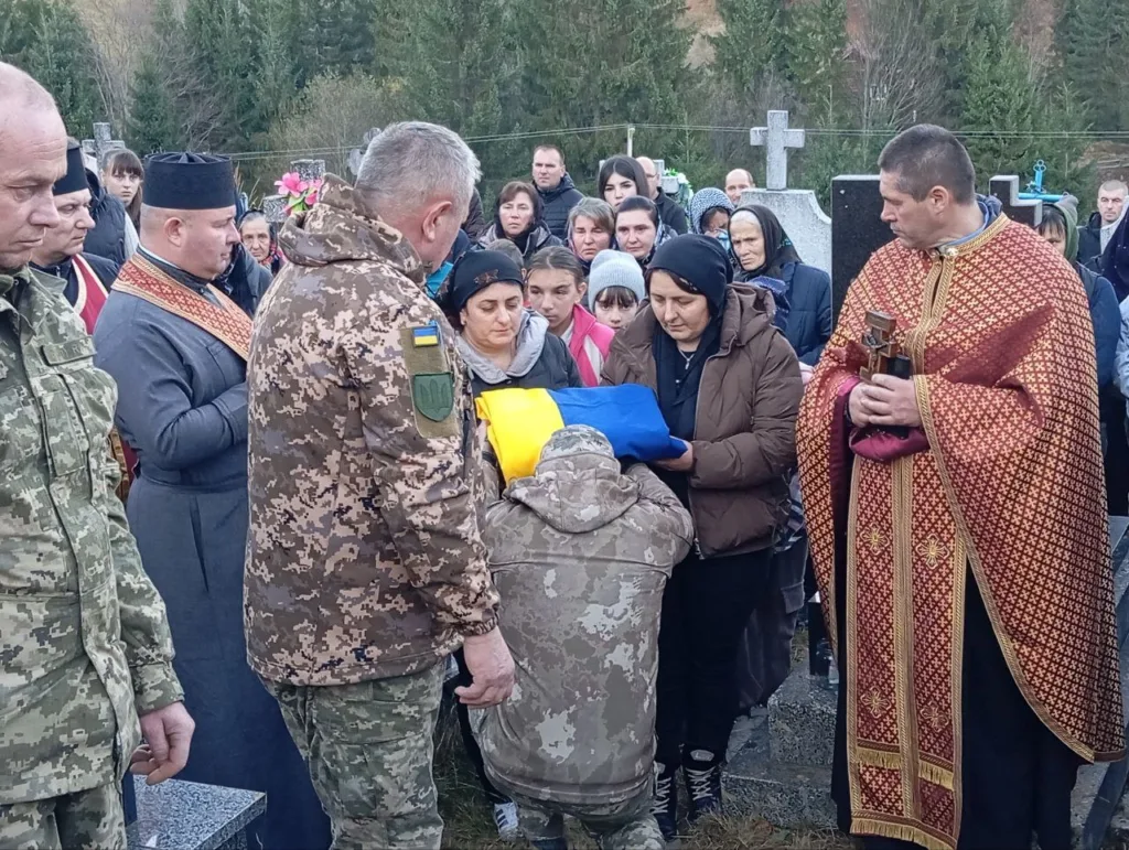 Похорон військового з українським прапором у присутності священника