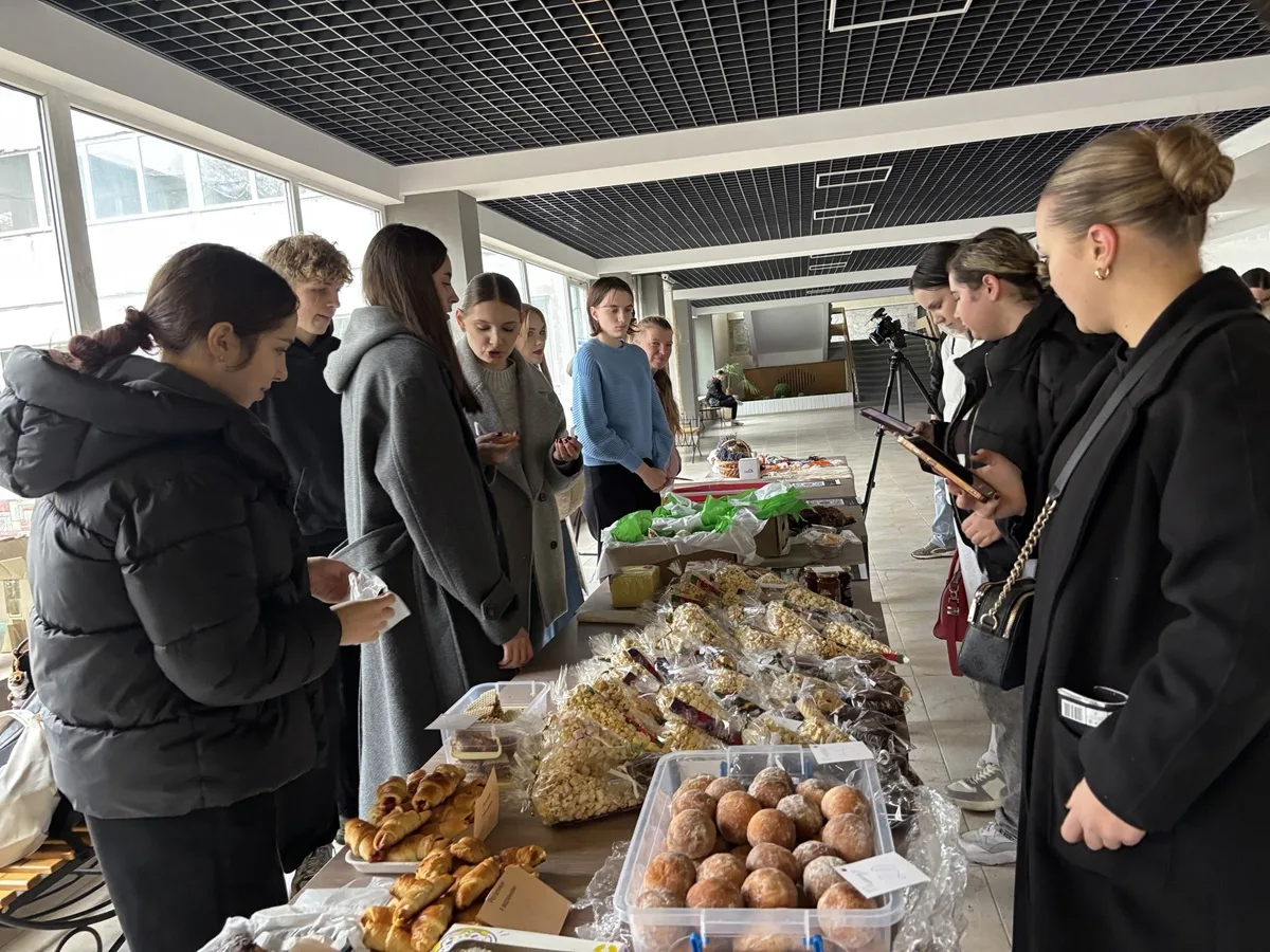 Люди на благодійному ярмарку з домашньою випічкою