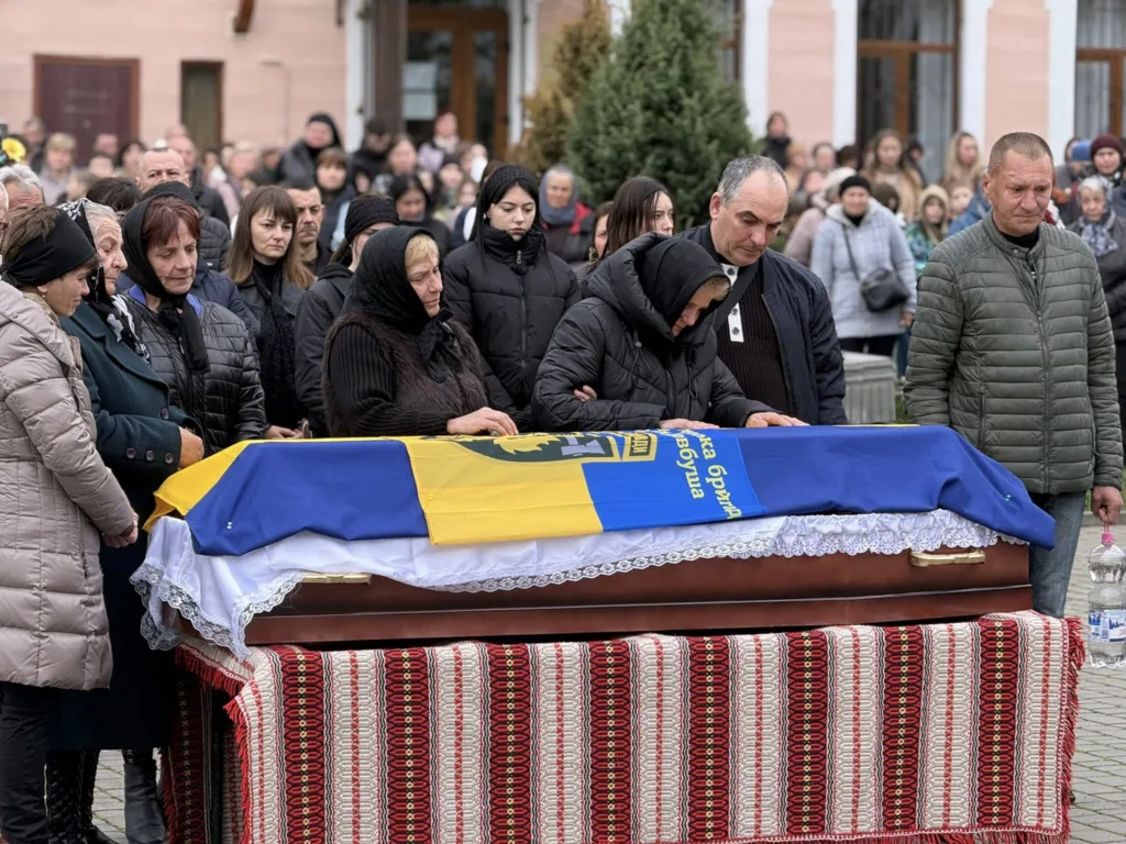 Люди прощаються з полеглим героєм під прапором України