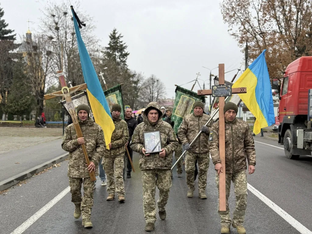 Українські військові несуть хрести та прапори