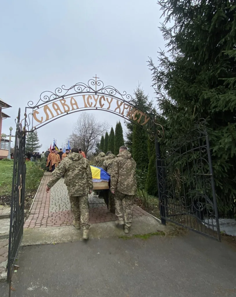 Військові несуть труну з українським прапором