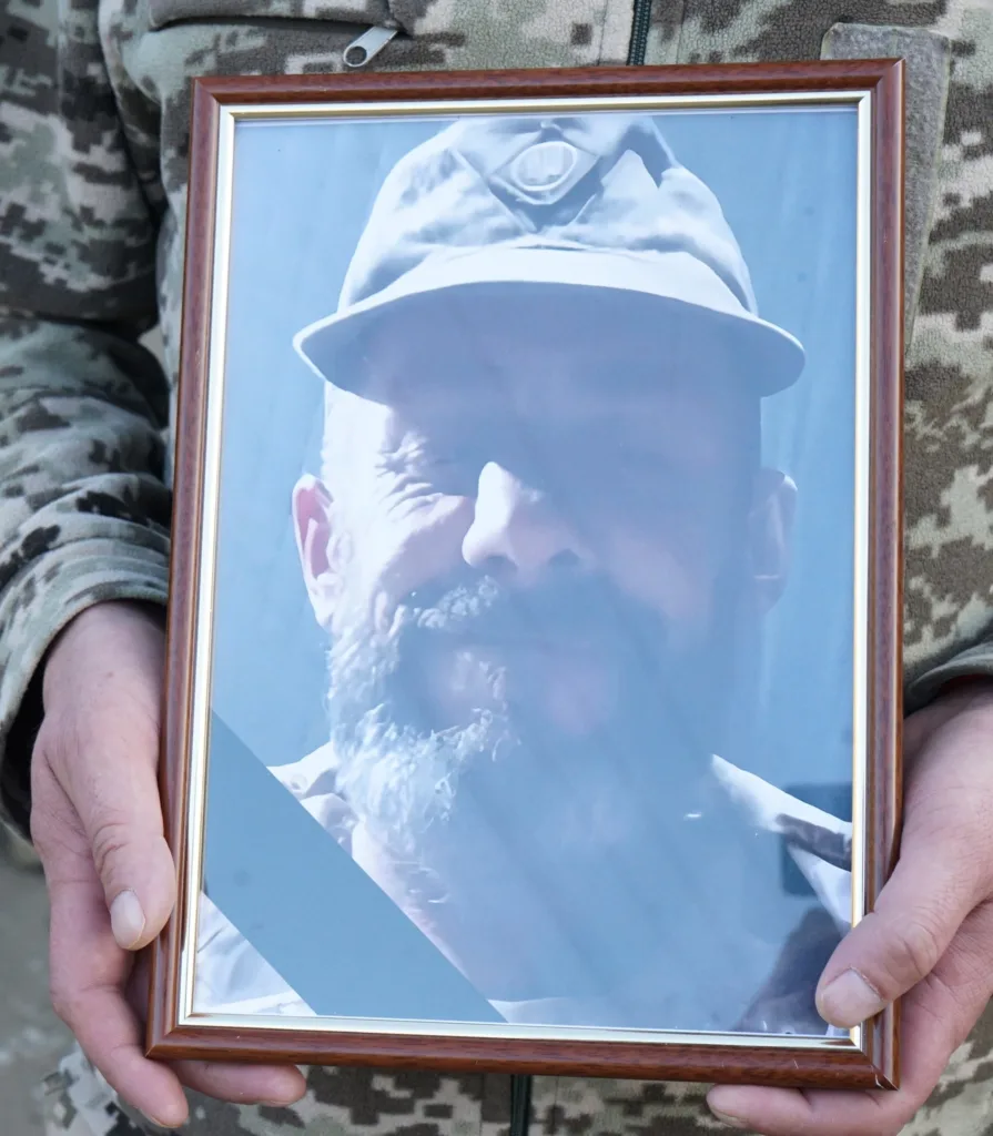 Військовий тримає портрет загиблого солдата