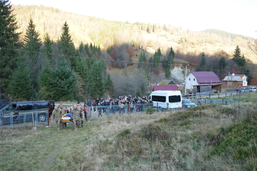 Військові несуть труну в гірському селі України