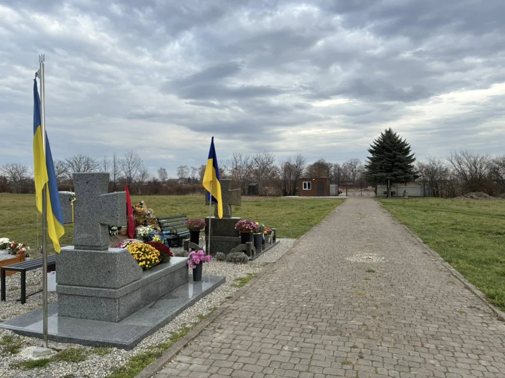 Меморіал з українськими прапорами та квітами