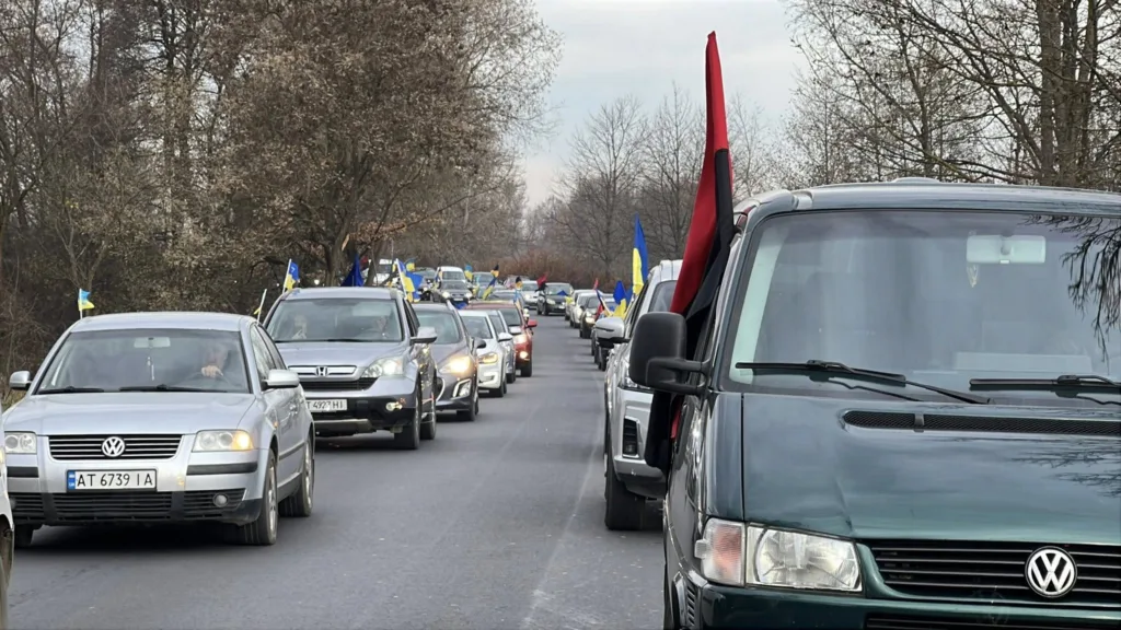 Автоколона з українськими прапорами на дорозі