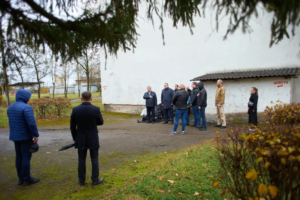 Група людей біля будівлі з написом укриття