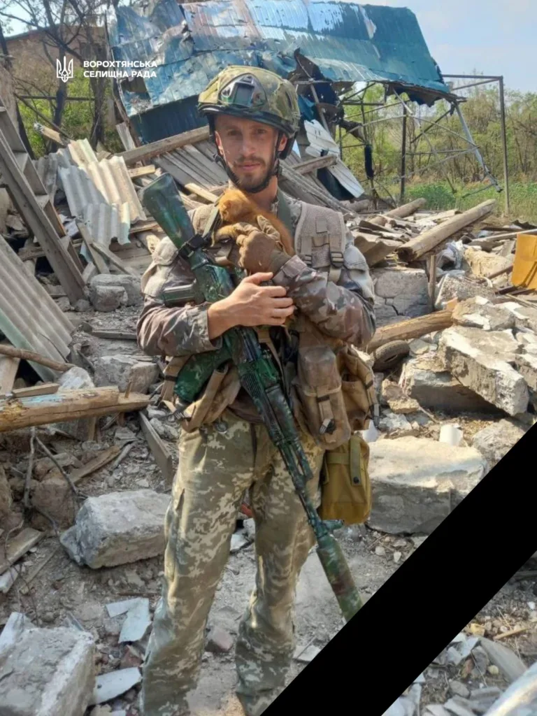 Український військовий тримає кошеня серед руїн