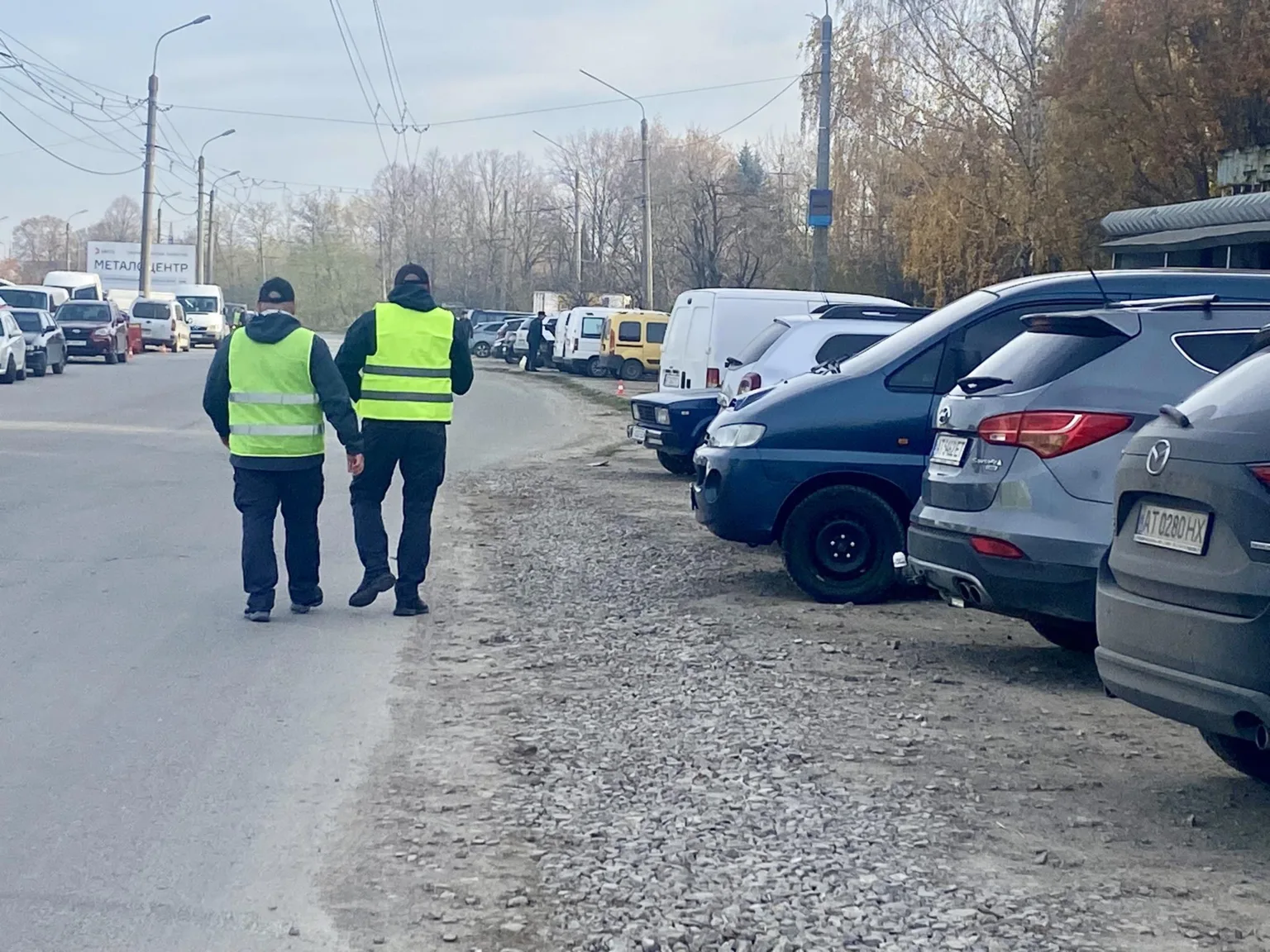 Двоє чоловіків у жовтих жилетах йдуть дорогою