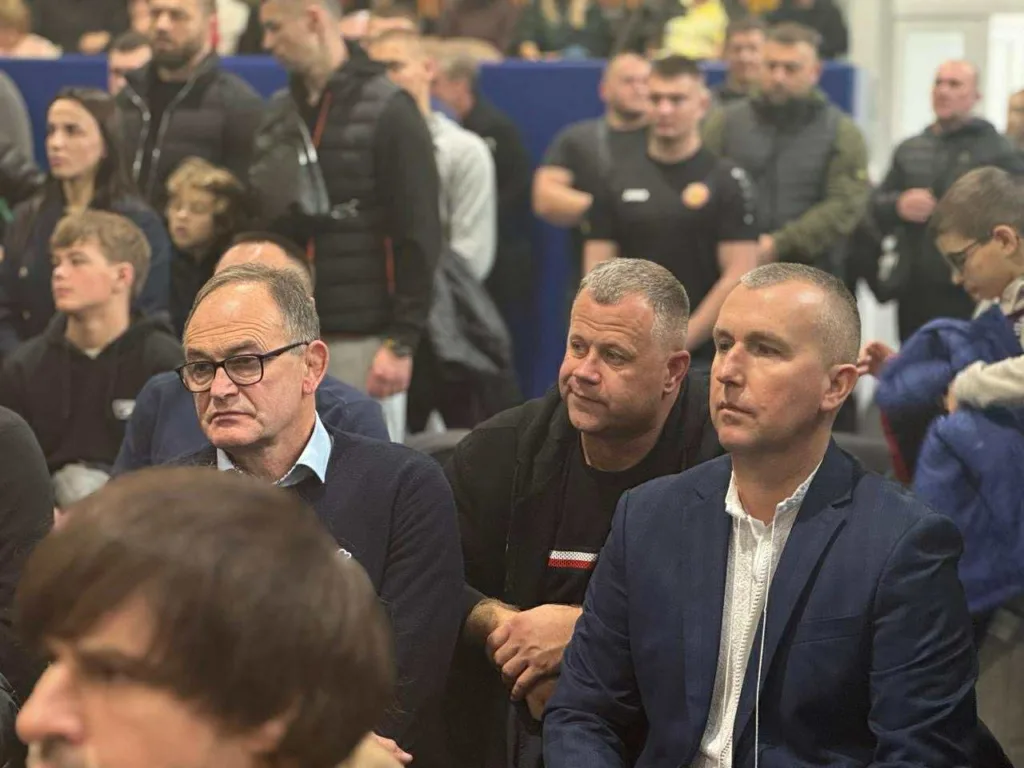 Люди сидять на громадському заході в залі