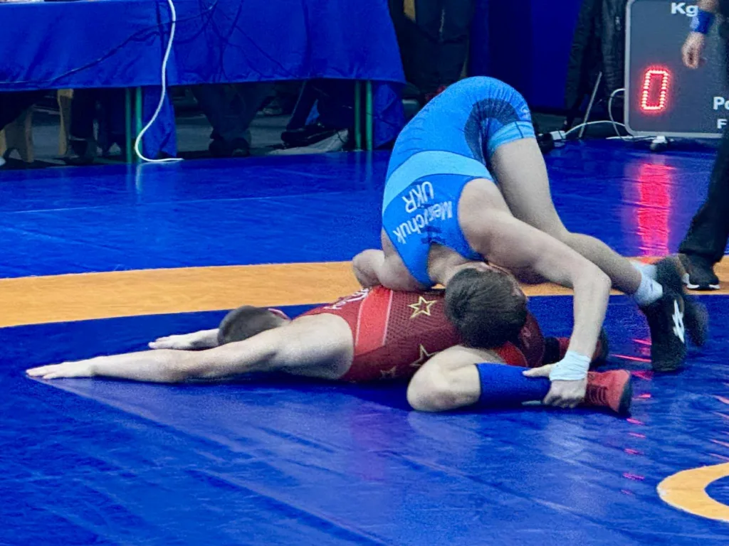 Боротьба двох спортсменів на синьому килимі