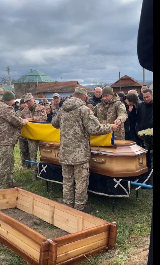 Військові прощаються із загиблим воїном під українським прапором