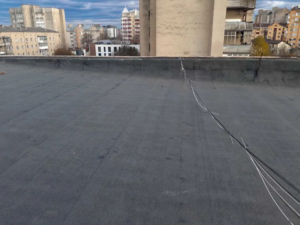 Плоский дах будівлі з кабелями та міським фоном