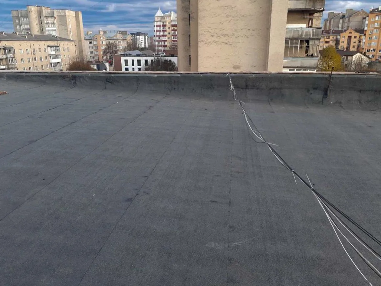 Плоский дах будівлі з кабелями та міським фоном