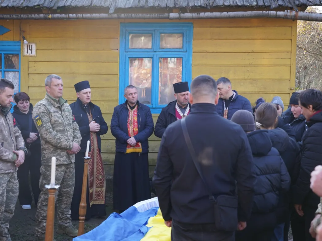 Військовий похорон біля жовтого будинку