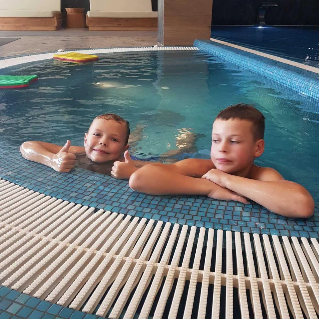 Двоє дітей купаються в басейні