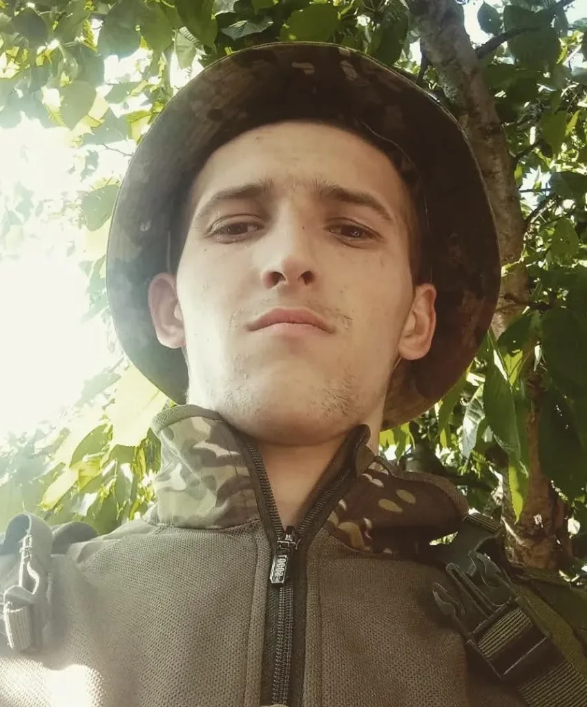 Чоловік у камуфляжі під деревом на природі