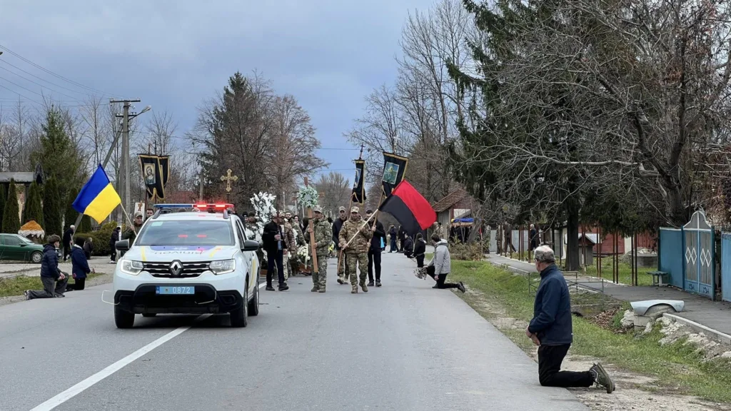 Похоронна процесія з військовими та прапорами України