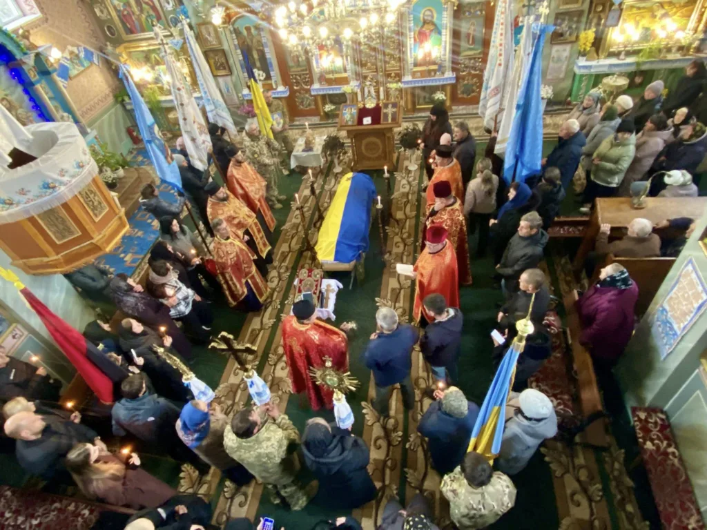 Поминальна служба в українській церкві з прапорами