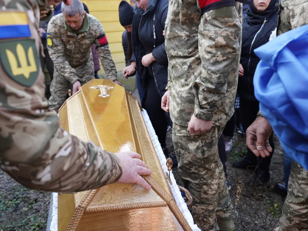 Військові несуть труну під час похорону героя