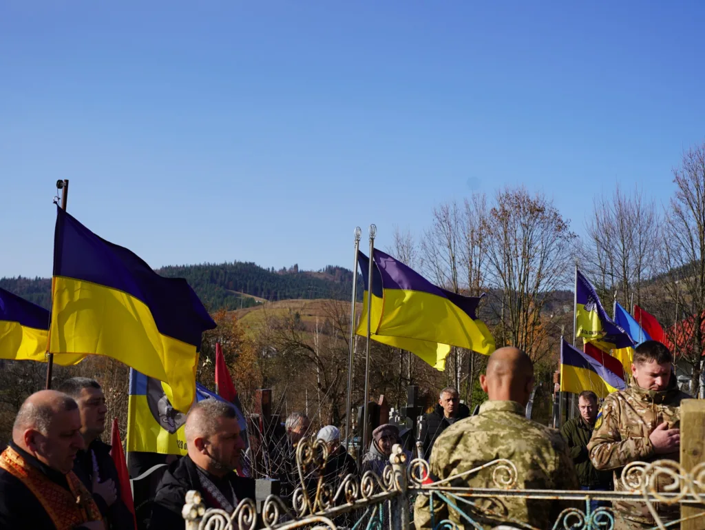 Люди з українськими прапорами на вшануванні героїв
